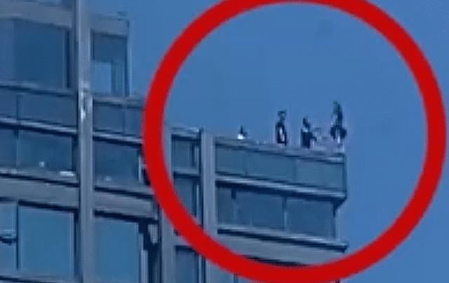 面前还|女子以跳水姿态站在三十层天台,面前一男子跪地乞求,画面令人揪心