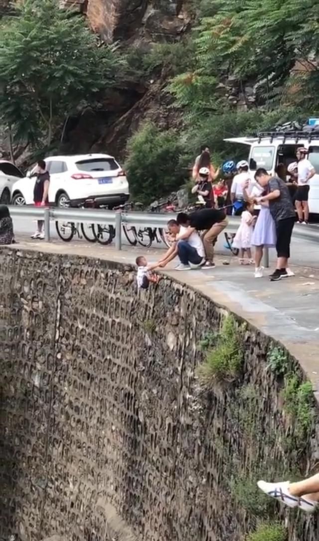  家长|这家长太不靠谱！竟然抓着孩子手挂在峭壁上拍照