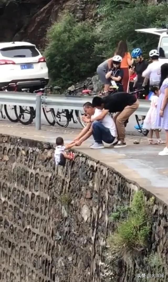 徒手|心真大！一家长竟徒手将孩子挂在峭壁上拍照，还故意抖动