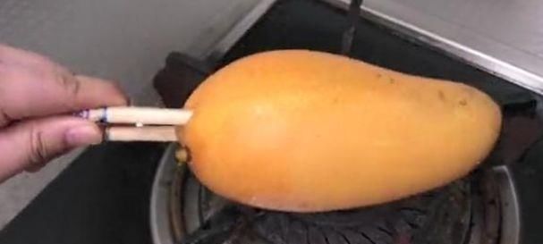 芒果|女子拿芒果在火上烤,又用刀划了两下,这操作结果神了