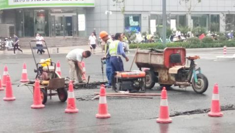  摆放|雨中路面出现三处破损，热心人及时摆放反光锥提醒车辆绕行
