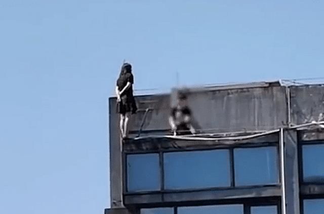 面前还|女子以跳水姿态站在三十层天台,面前一男子跪地乞求,画面令人揪心