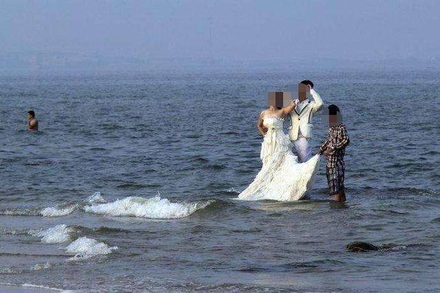 新娘|新娘海边拍照被浪卷走：穿婚纱死亡，新郎紧握女子手低头悲戚